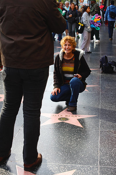 Women kneeling to take a picture on a star.