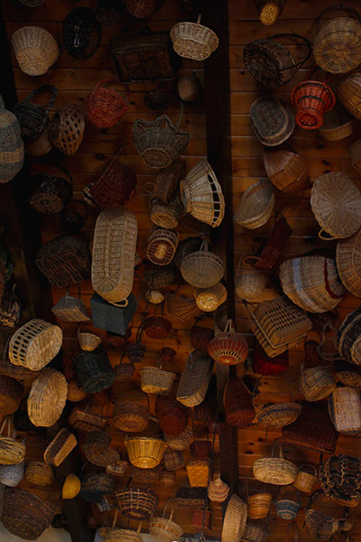 On the roof of the room there are many baskets hanging.